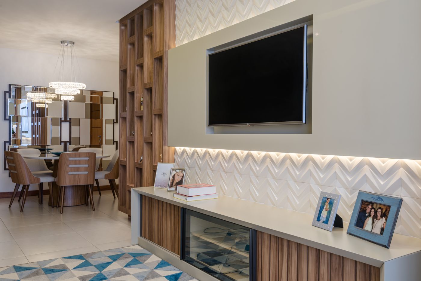 Painel de TV com revestimento em zigue-zague e rack de madeira com luz embutida